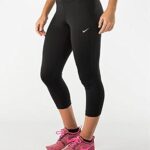Woman wearing black leggings and pink sneakers.
