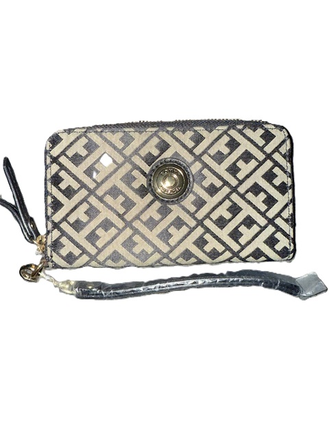 Patterned wallet with strap and circular clasp.
