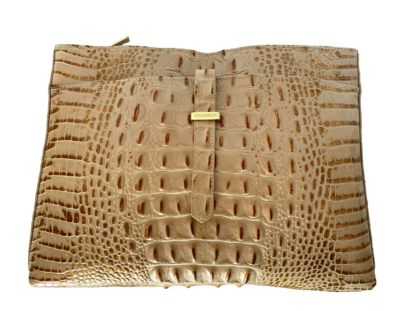 Golden crocodile-patterned leather handbag with clasp.